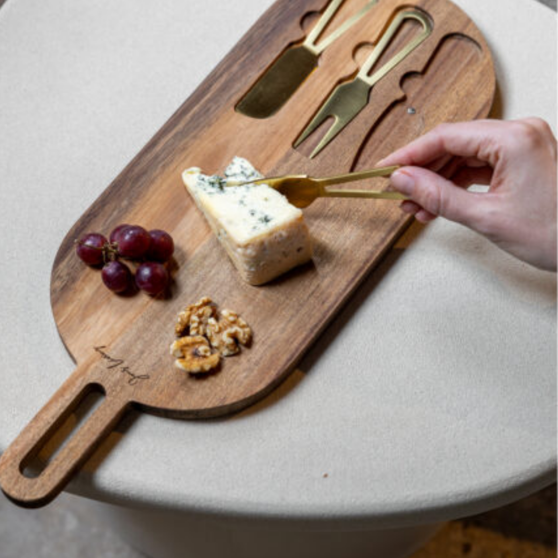 Servierbrett mit goldenen Käsemessern